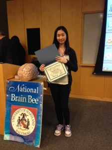 Hetince stands with her certificate after competing at the National Brain Bee at the University of Maryland.